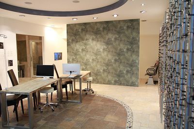 Modernes Büro mit Schreibtischen, Computern und stilvoller Wandgestaltung im Empfangsbereich.